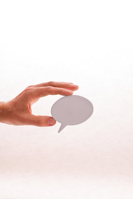 Minimalistic image of a hand holding a blank speech bubble, perfect for communication themes.